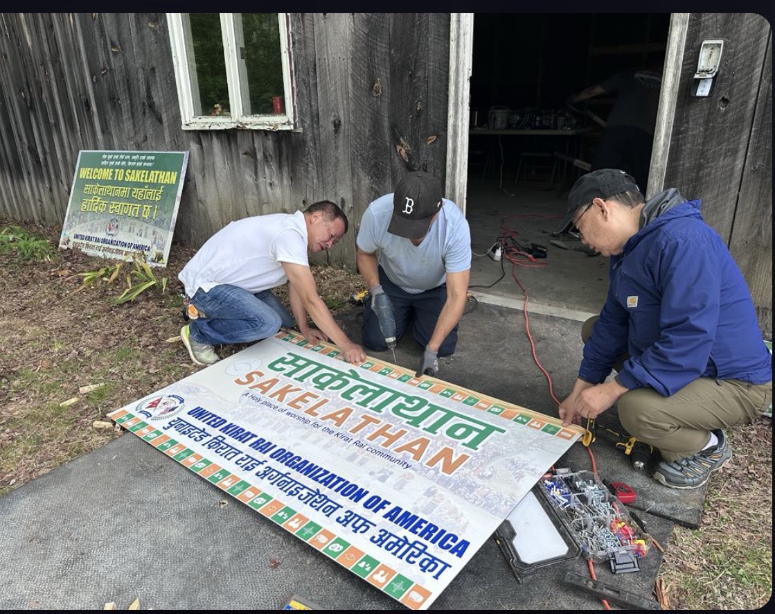 Community volunteers preparing the Sakelathan sign in Brimfield, Massachusetts